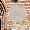 Kamień młyński wmurowany w fasadę kościoła