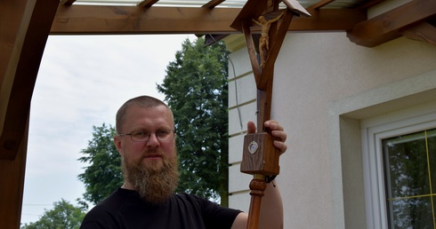Ojciec Grzegorz Filipiuk OFMCap trzyma krzyż z relikwiami bł. o. Honorata.