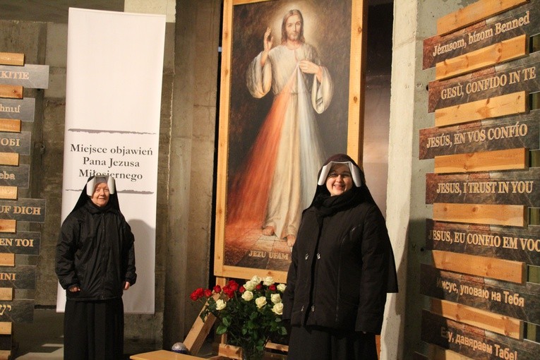 Siostry Matki Bożej Miłosierdzia przy obrazie Jezusa Miłosiernego, otoczonego wezwaniami: "Jezu, ufam Tobie" w kilkunastu językach